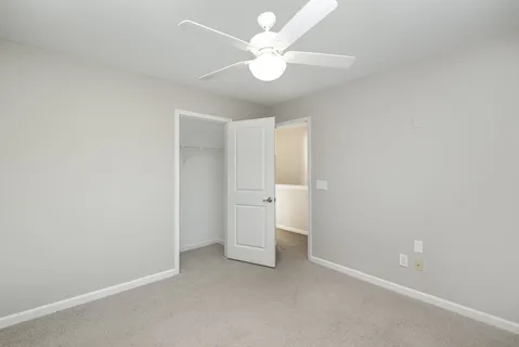 an empty room with a ceiling fan and a fan