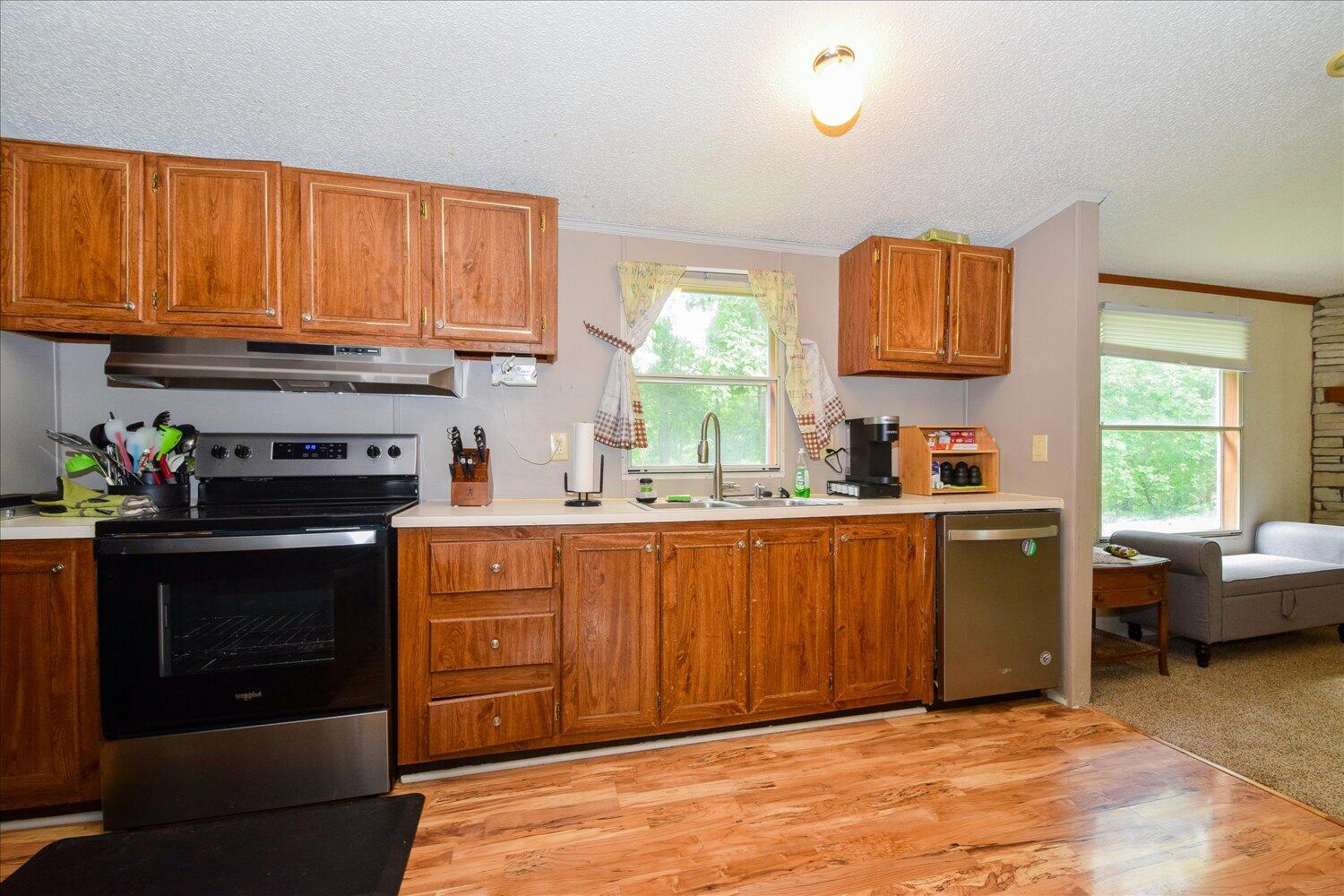6423 Meacham Road Salem, VA 24153 - Photo 7 of 29 a kitchen with stainless steel appliances granite countertop a stove a sink dishwasher and a microwave oven with cabinets