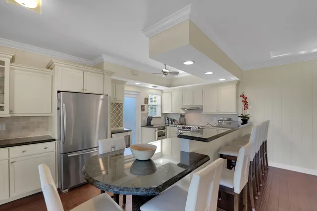 a kitchen with stainless steel appliances granite countertop a sink a refrigerator and a stove