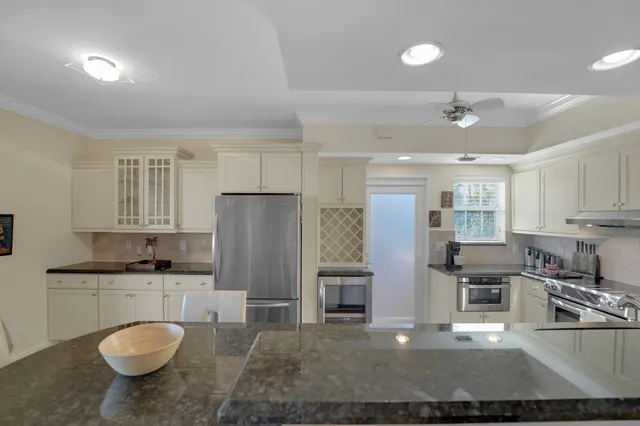 a kitchen with stainless steel appliances granite countertop a sink a stove a refrigerator and cabinets