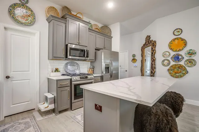 a kitchen with stainless steel appliances granite countertop a stove and a refrigerator