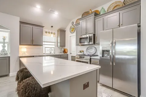 a kitchen with stainless steel appliances granite countertop a sink a stove and a refrigerator