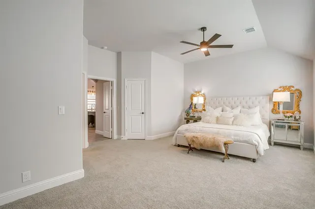 a spacious bedroom with a bed and a chandelier