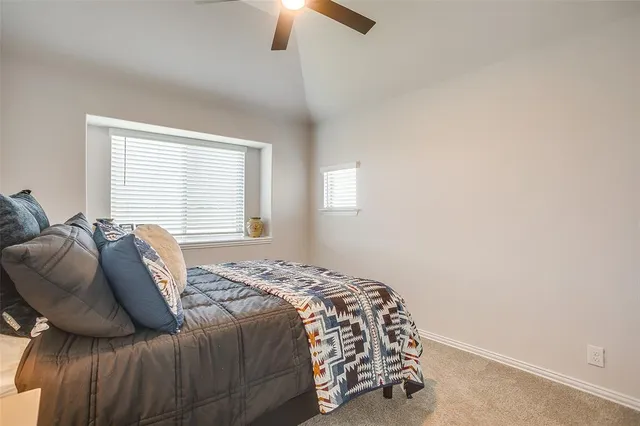 a bed sitting in a bedroom next to a window and a chandelier