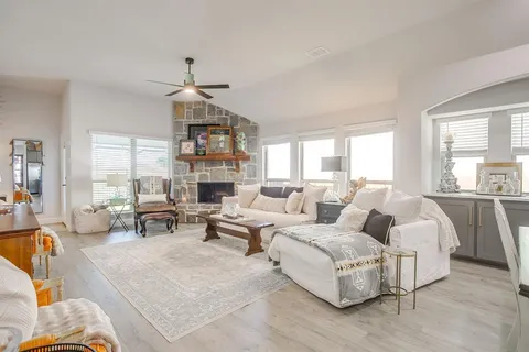 a living room with furniture fireplace and large windows