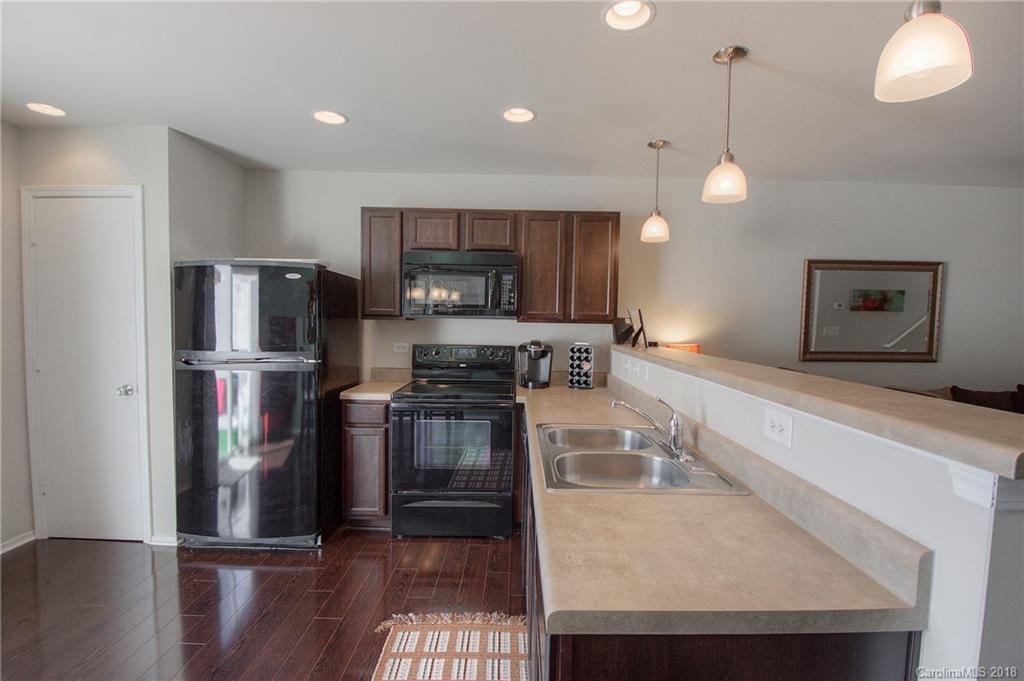 311 River Clay Road Fort Mill, SC 29708 - Photo 11 of 26 a kitchen with stainless steel appliances granite countertop a refrigerator a stove a sink a microwave a refrigerator and white cabinets with wooden floor