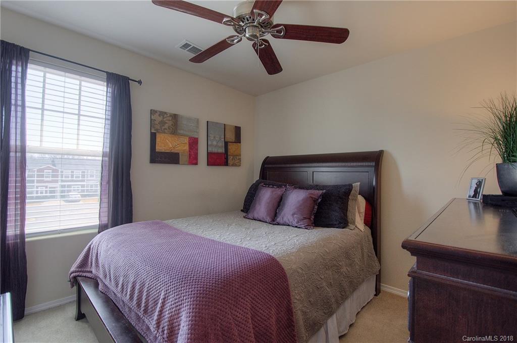 311 River Clay Road Fort Mill, SC 29708 - Photo 18 of 26 a bedroom with a large bed and a chandelier
