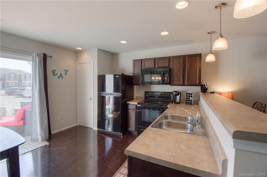 311 River Clay Road Fort Mill, SC 29708 - Photo 6 of 26 a kitchen with stainless steel appliances granite countertop a refrigerator a stove top oven a sink dishwasher and wooden cabinets with wooden floor