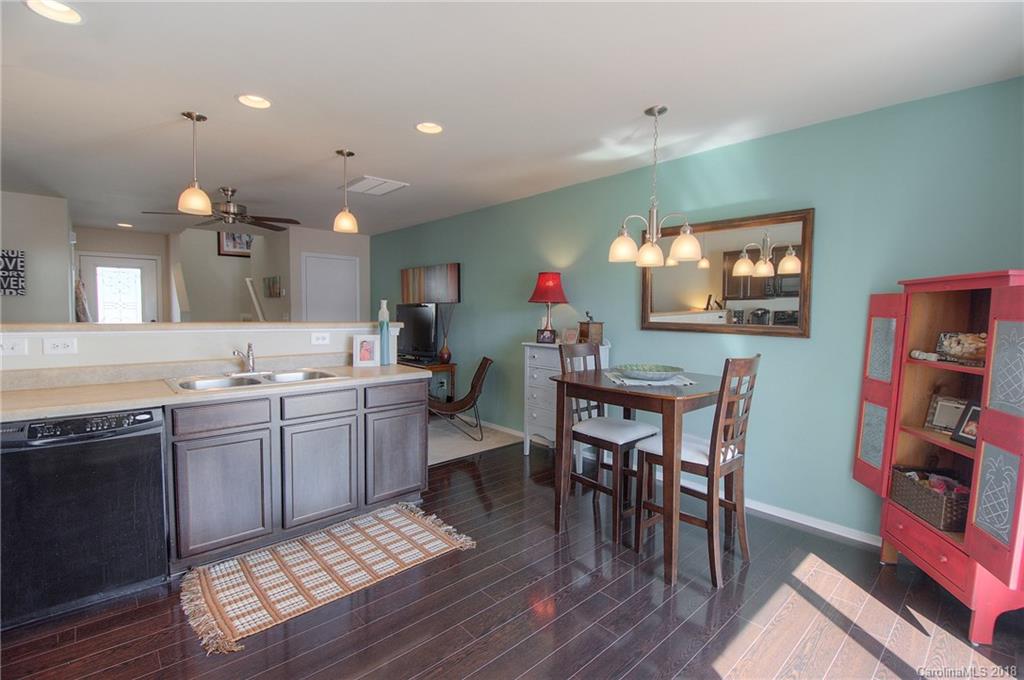 311 River Clay Road Fort Mill, SC 29708 - Photo 8 of 26 a kitchen with stainless steel appliances granite countertop a sink dishwasher a stove a dining table and chairs with wooden floor