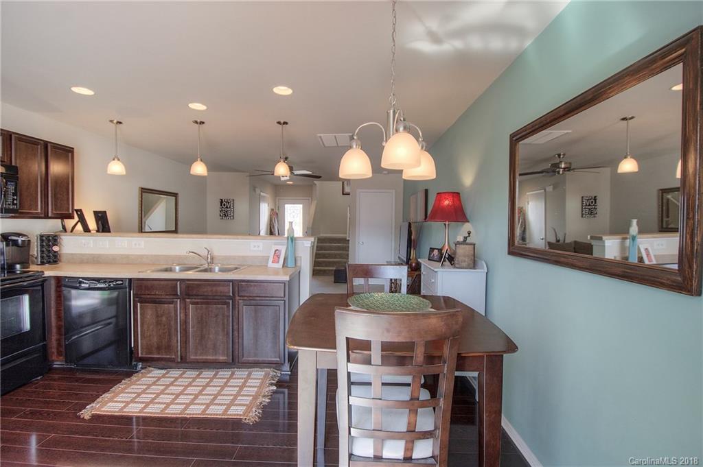 311 River Clay Road Fort Mill, SC 29708 - Photo 10 of 26 a kitchen with kitchen island granite countertop a stove a sink a oven and a dining table with wooden floor