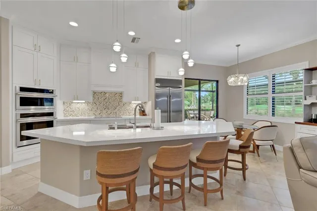 a kitchen that has a sink and a stove with white walls