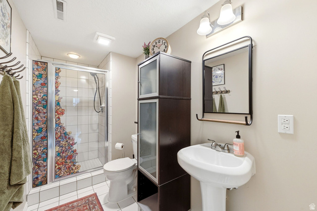1112 Eagle Ridge Circle Sandy, UT 84094 - Photo 25 of 38 Bathroom featuring a pedestal sink, framed mirror with integrated shelf, and a shower with glass enclosure