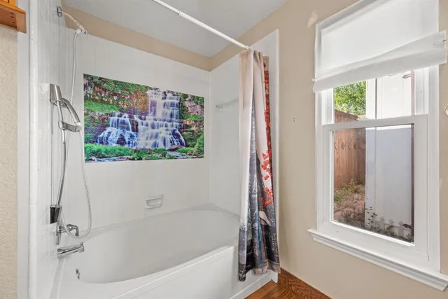 a bathroom with a bathtub and a window
