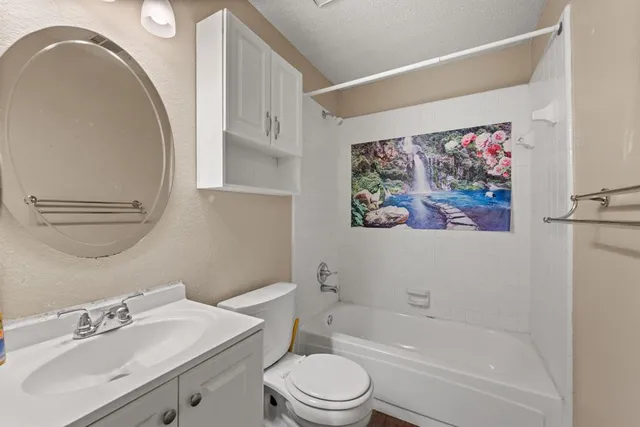 a bathroom with a sink mirror vanity and toilet