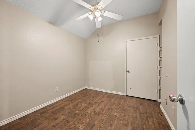 wooden floor in an empty room with a fan
