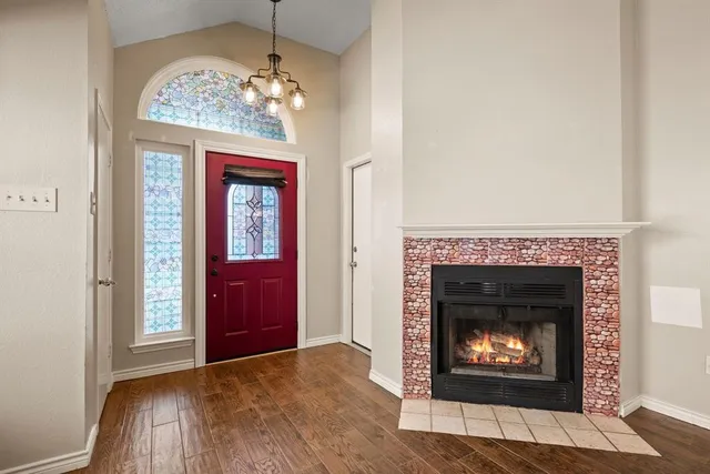 an empty room with a fireplace and wooden floor