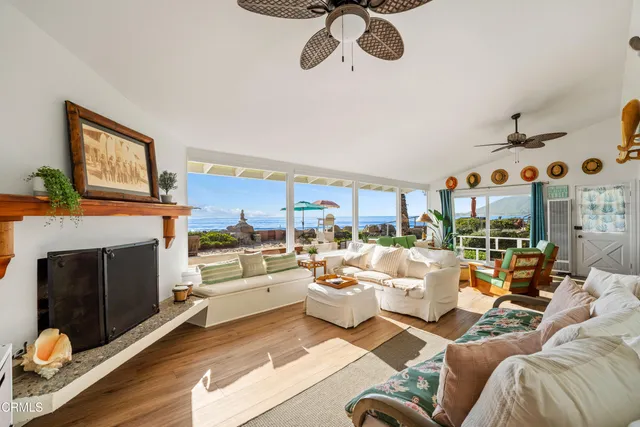 a living room with furniture kitchen view and a fireplace