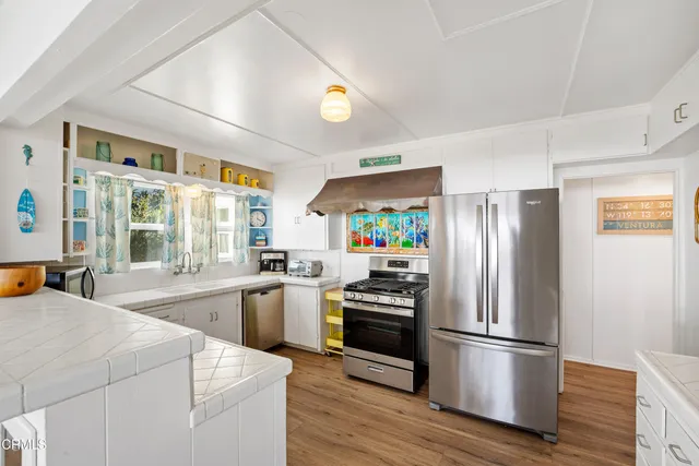 a kitchen with stainless steel appliances a refrigerator sink and stove