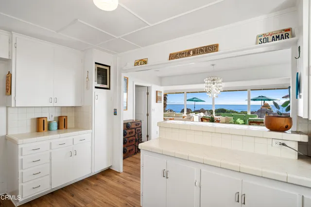 a kitchen with cabinets and wooden floor