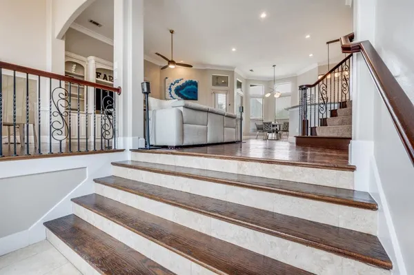 a view of staircase with lots of frames on wall and a table