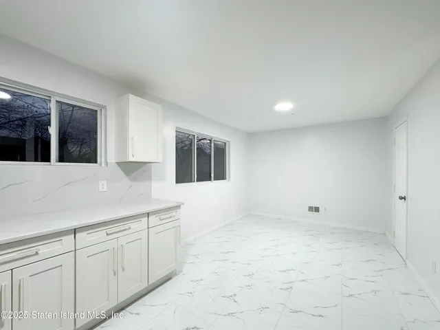 a view of an empty room with a kitchen