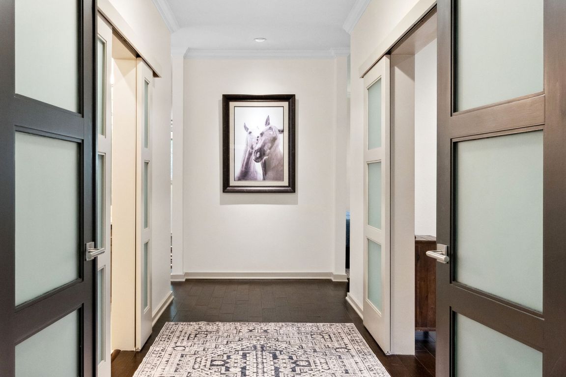 9 Swiftwater Trail The Hills, TX 78738 - Photo 18 of 34 Hallway featuring crown molding and dark wood-style flooring