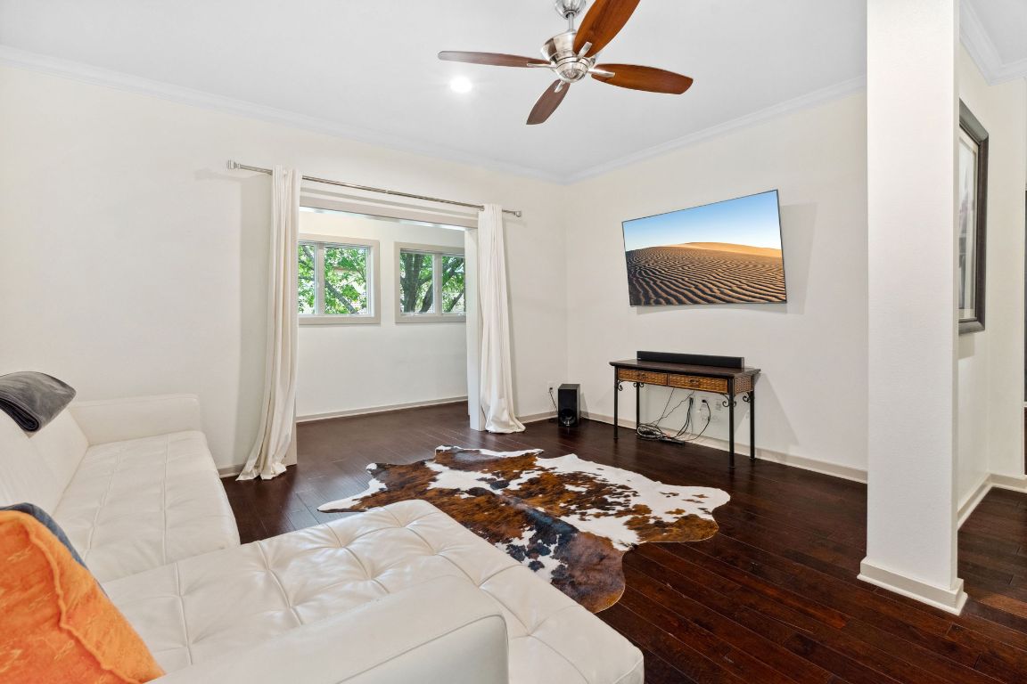 9 Swiftwater Trail The Hills, TX 78738 - Photo 21 of 34 Living area featuring ornamental molding, dark wood-style flooring, and a ceiling fan