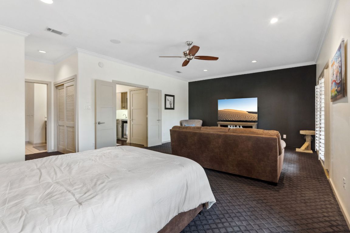 9 Swiftwater Trail The Hills, TX 78738 - Photo 26 of 34 Bedroom with crown molding, connected bathroom, recessed lighting, dark carpet, and a closet