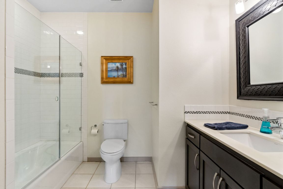 9 Swiftwater Trail The Hills, TX 78738 - Photo 28 of 34 Full bathroom with light tile patterned floors, vanity, and bath / shower combo with glass door