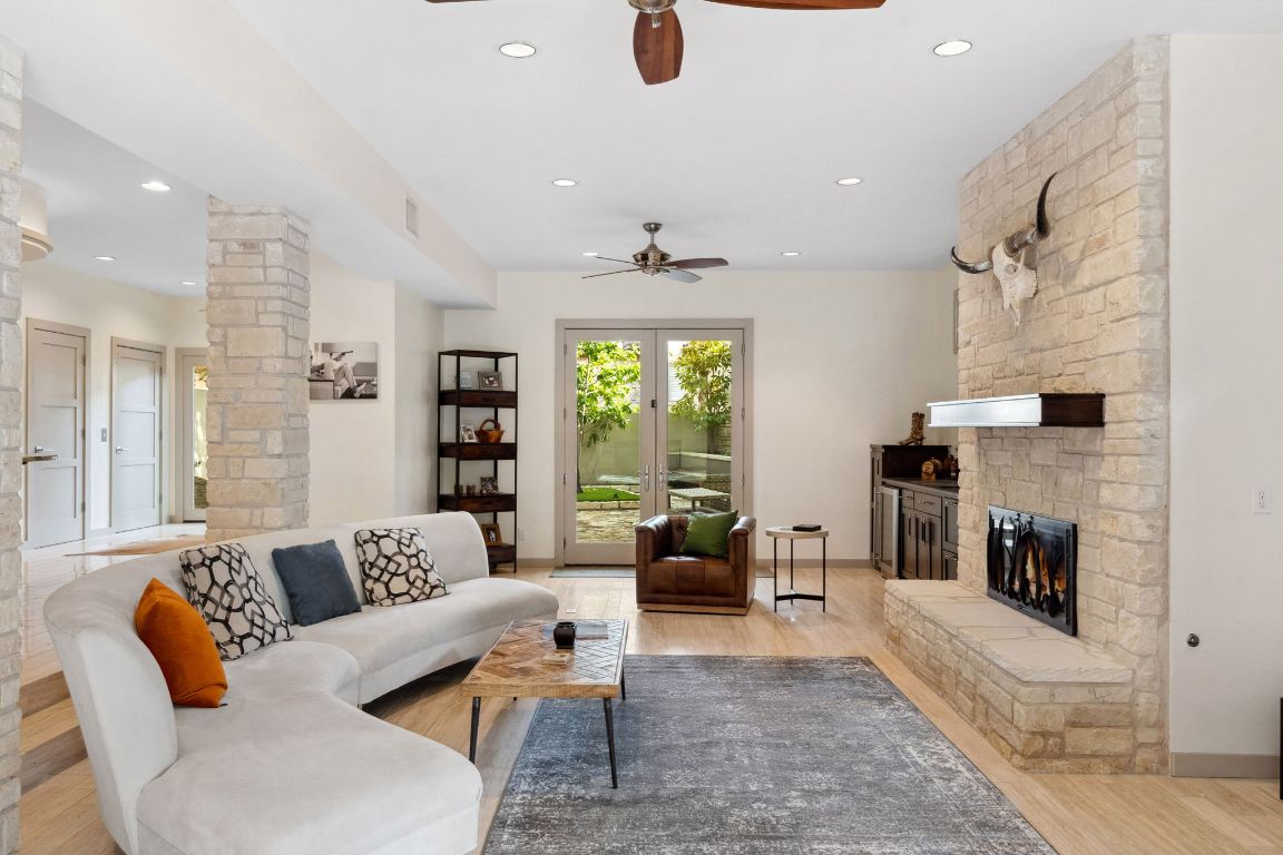 9 Swiftwater Trail The Hills, TX 78738 - Photo 8 of 34 Living room with decorative columns, a ceiling fan, light wood-type flooring, recessed lighting, and a fireplace