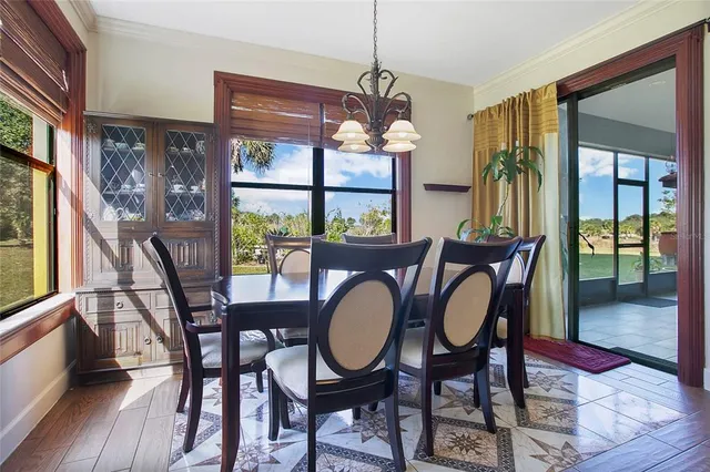 a dining room with furniture a chandelier and wooden floor
