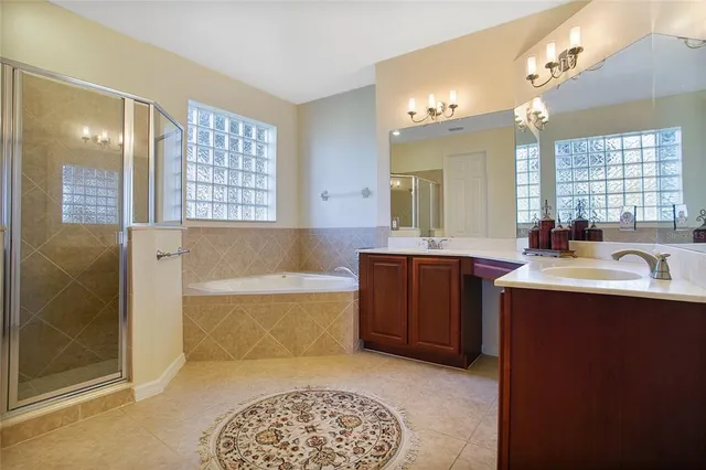 a spacious bathroom with a tub sink and mirror