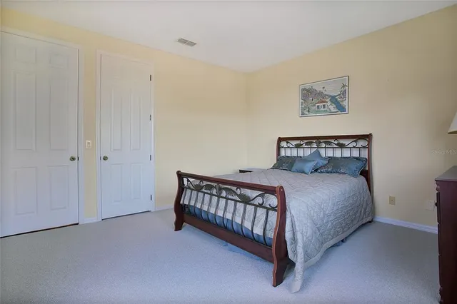 a bedroom with a bed and painting on the wall