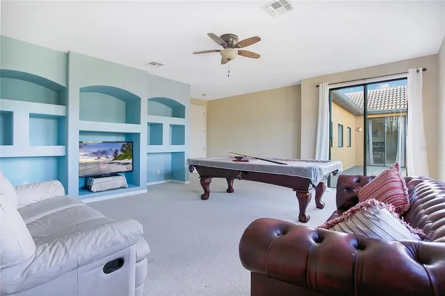 a living room with furniture and a ceiling fan