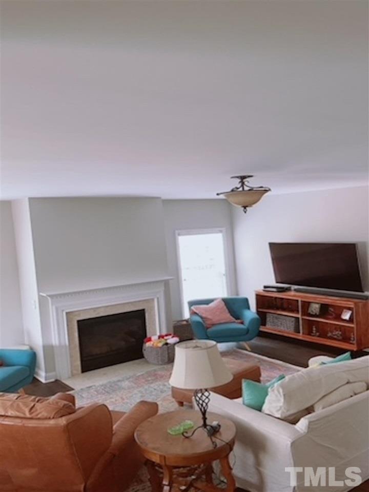 407 Challenge Road Raleigh, NC 27603 - Photo 11 of 29 a living room with furniture a fireplace and a flat screen tv