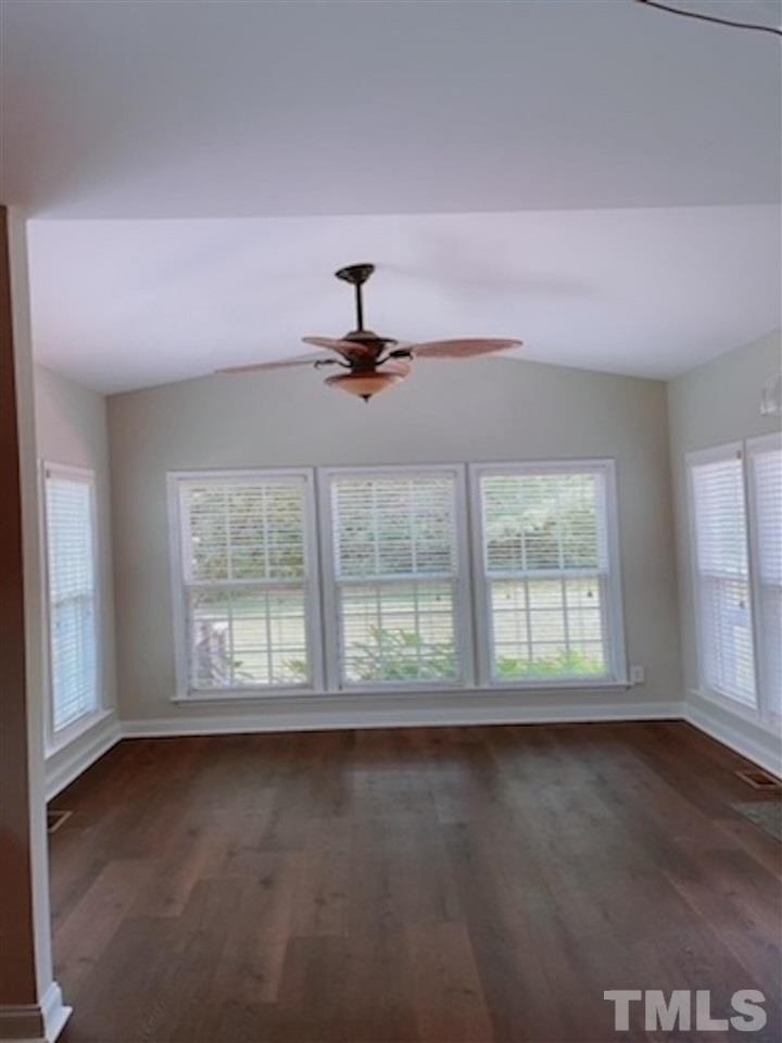 407 Challenge Road Raleigh, NC 27603 - Photo 9 of 29 an empty room with wooden floor fan and windows