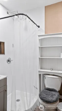 a bathroom with a toilet and a shower