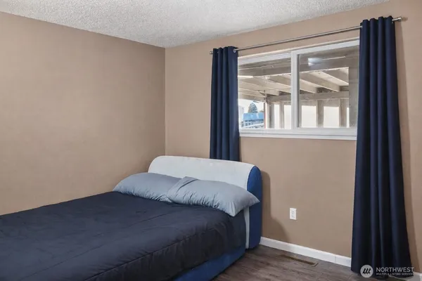a bed sitting in a bedroom next to a window