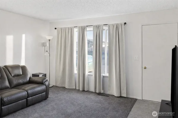 a living room with furniture a closet and a large window