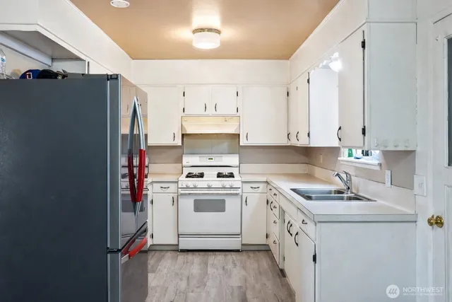 a view of a kitchen with a refrigerator and a sink