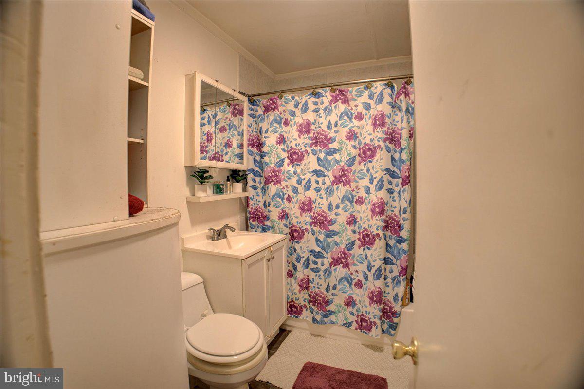 16 Taxi Way Middle River, MD 21220 - Photo 11 of 16 a white toilet sitting next to a shower curtain