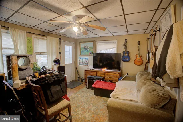 a living room with furniture a flat screen tv and a window