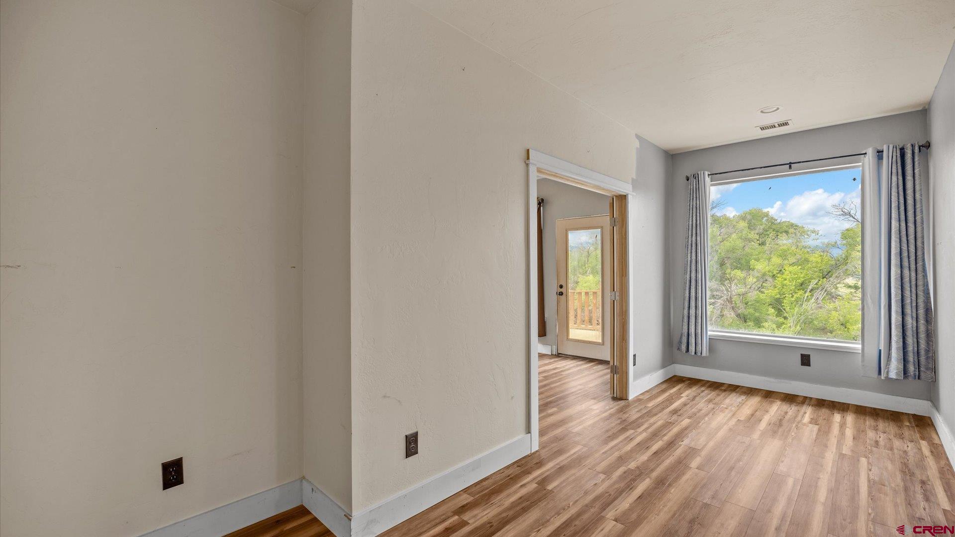 9097 2150th Road Austin, CO 81410 - Photo 13 of 19 an empty room with wooden floor and windows