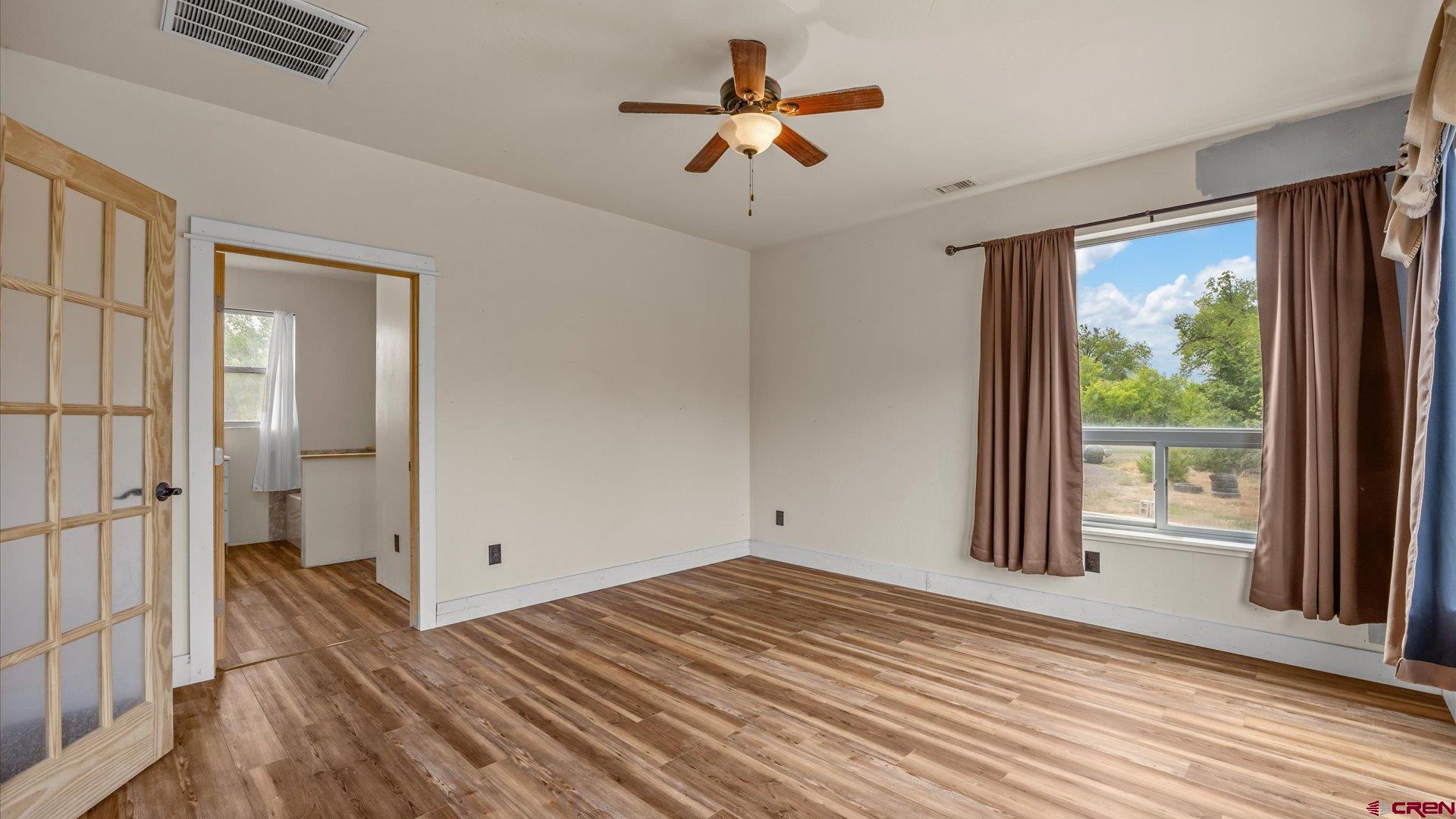 9097 2150th Road Austin, CO 81410 - Photo 14 of 19 a view of empty room with wooden floor and fan