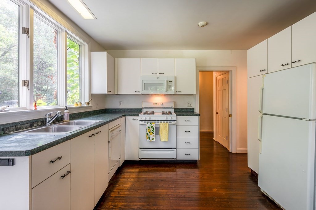 893 Highland Street Hamilton, MA 01982 - Photo 21 of 42 a kitchen with a refrigerator stove and wooden cabinets