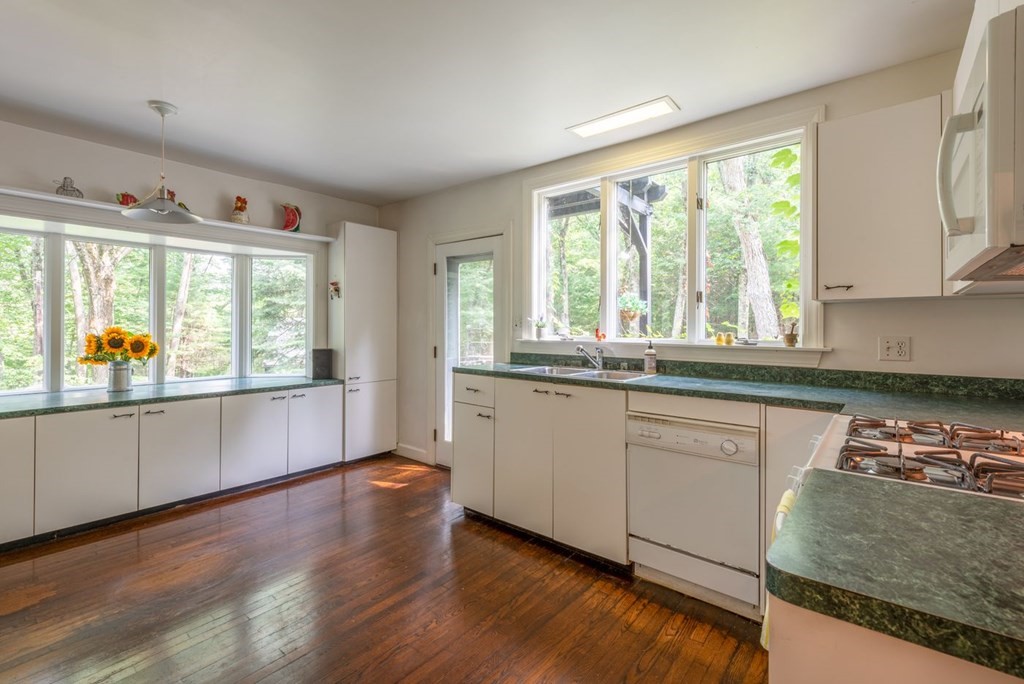 893 Highland Street Hamilton, MA 01982 - Photo 22 of 42 a kitchen with stainless steel appliances granite countertop a stove a sink and a large window