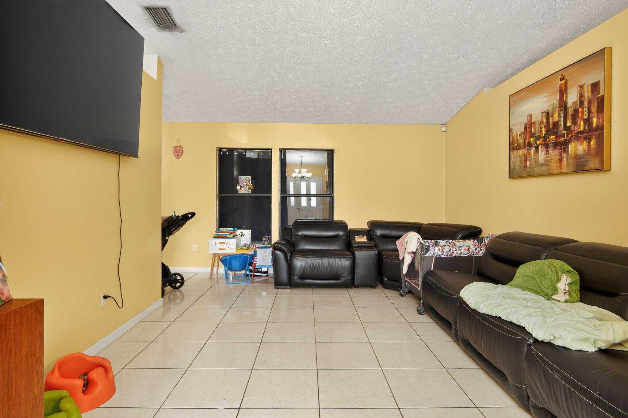 3053 Southeast Wake Road Port St. Lucie, FL 34984 - Photo 21 of 28 a living room with furniture and a floor to ceiling window