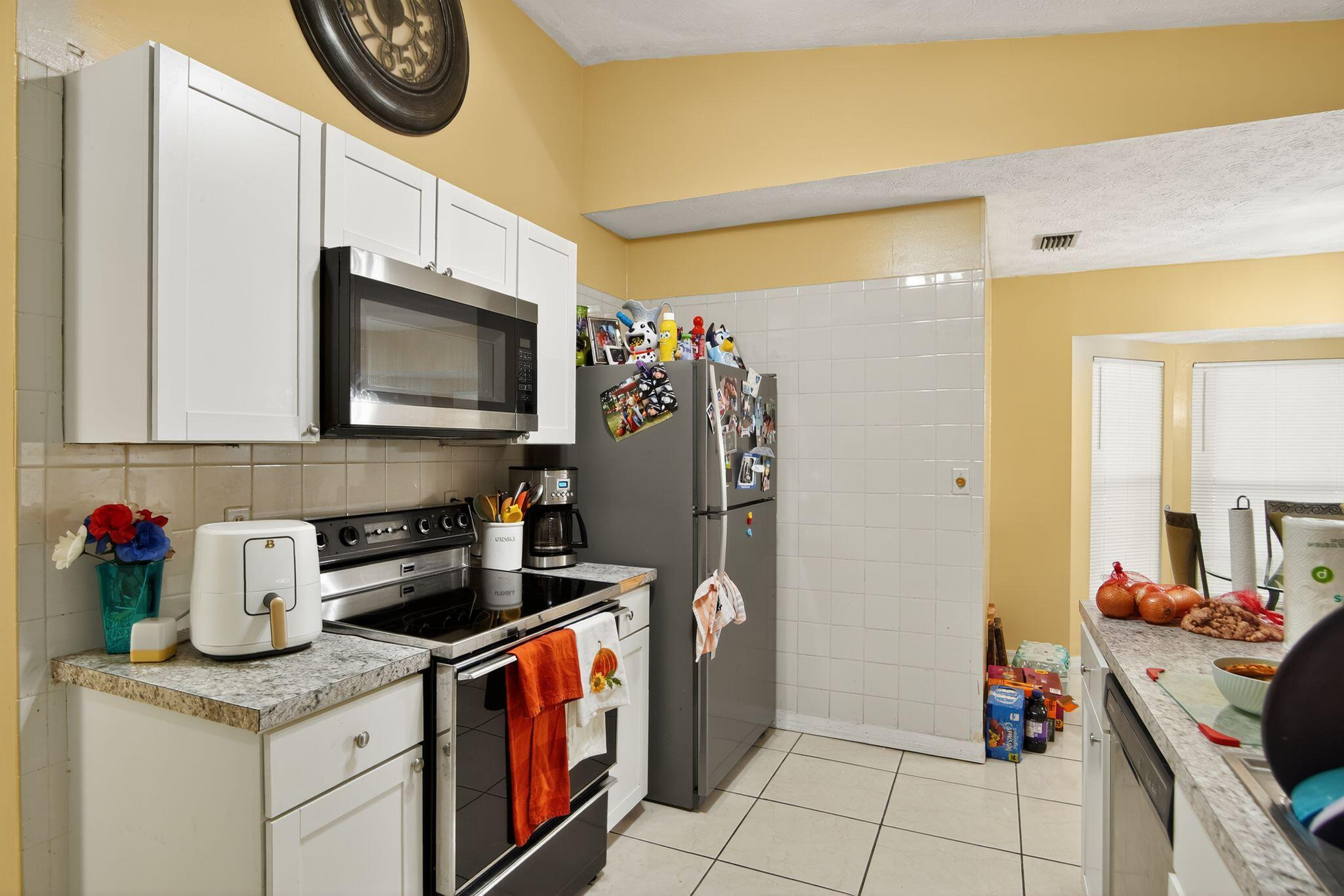 3053 Southeast Wake Road Port St. Lucie, FL 34984 - Photo 24 of 28 a kitchen with stainless steel appliances granite countertop a stove and a sink