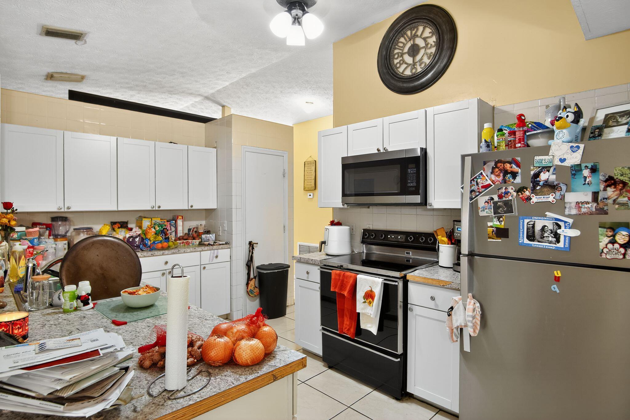 3053 Southeast Wake Road Port St. Lucie, FL 34984 - Photo 25 of 28 a kitchen with stainless steel appliances a stove and cabinets