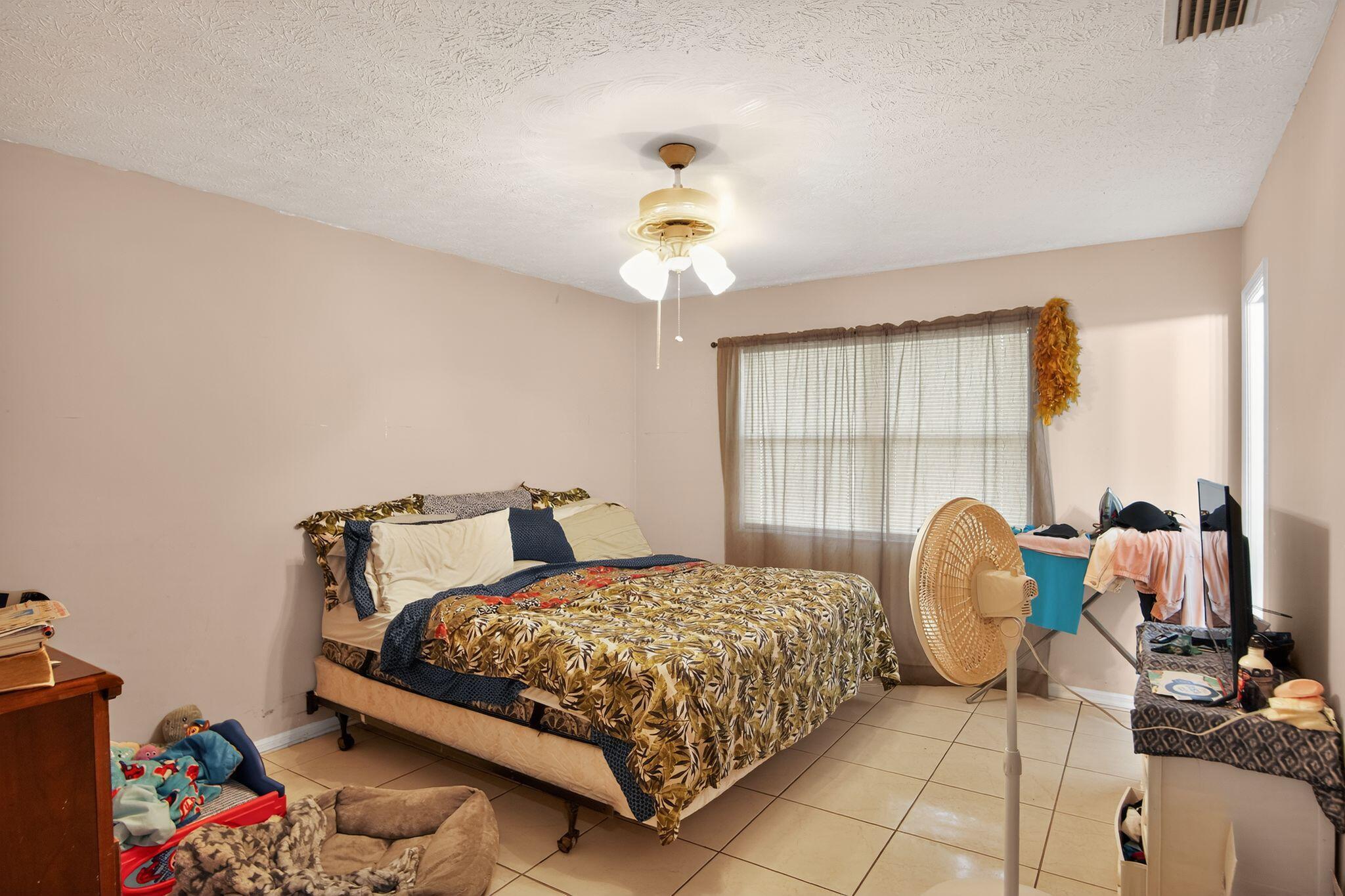 3053 Southeast Wake Road Port St. Lucie, FL 34984 - Photo 3 of 28 a bedroom with a bed and window